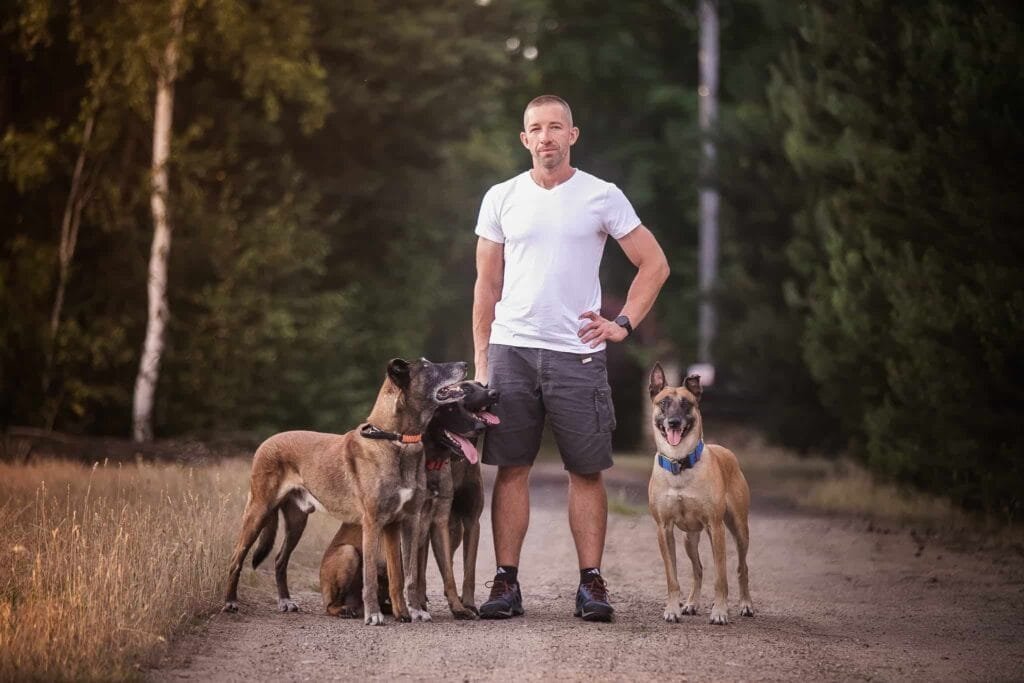 Patryk z czteroma psami patrzy się w obiektyw